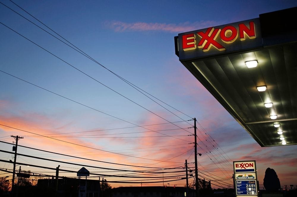 An Exxon Mobil petrol station with clouds lit by a sunset in background