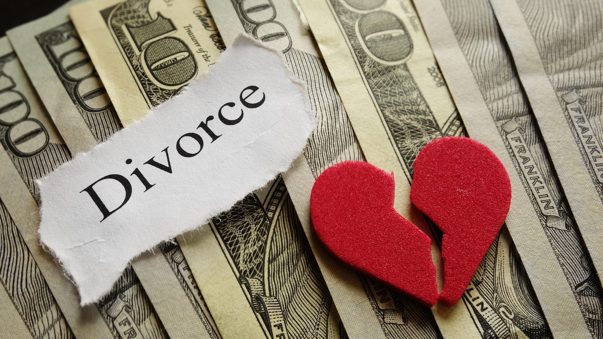 Picture of money with a paper saying divorce and a broken heart