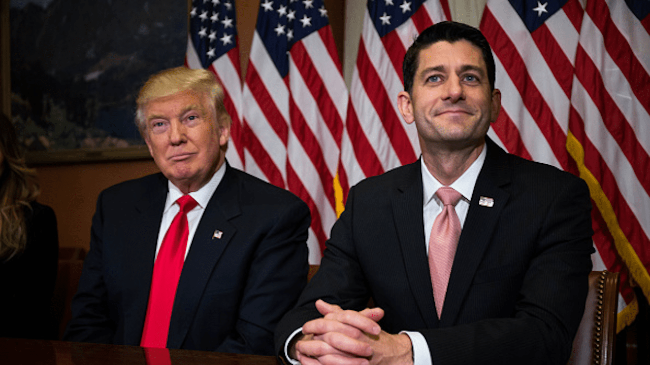 President Trump and House Speaker Paul Ryan sit side-by-side in front of a row of American flags.