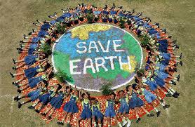 Students lying on the ground in a circle around a globe painted on the lawn. The center of the globe says "Save Earth."