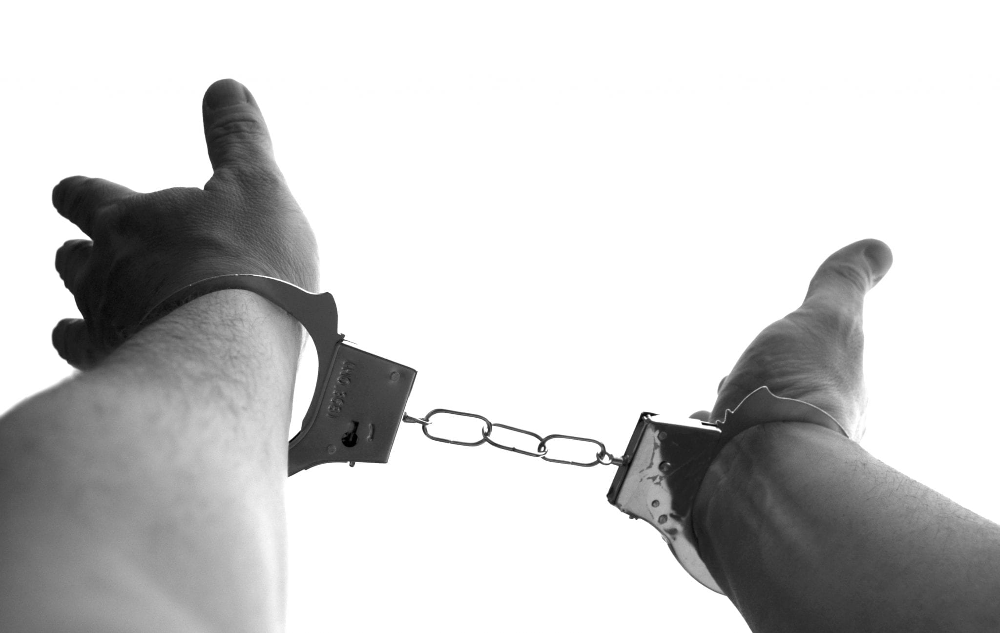 Man in handcuffs; image via Pxhere, CC0.