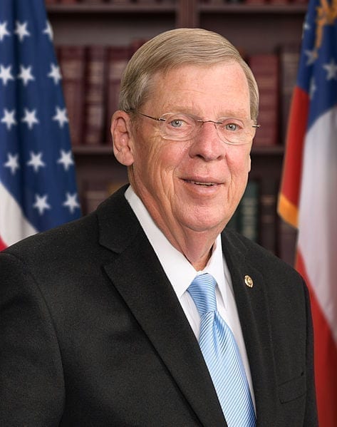 Senator Johnny Isakson's official photo, with an American flag background.