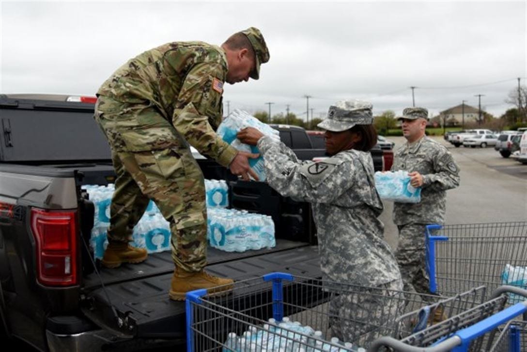 Members of the Texas National Guard load a truck with bottled water to assist with the Flint water crisis.
