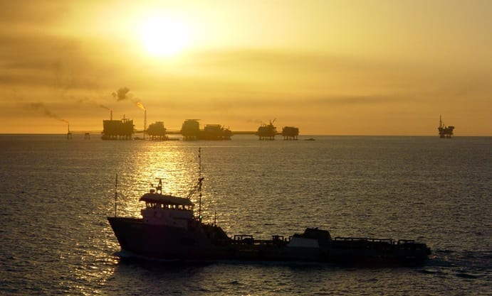 A ship and oil rigs in the Gulf of Mexico, at twilight.
