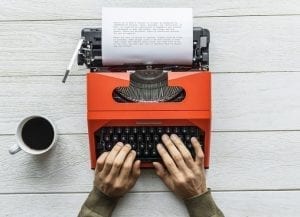 Writer typing on a typewriter