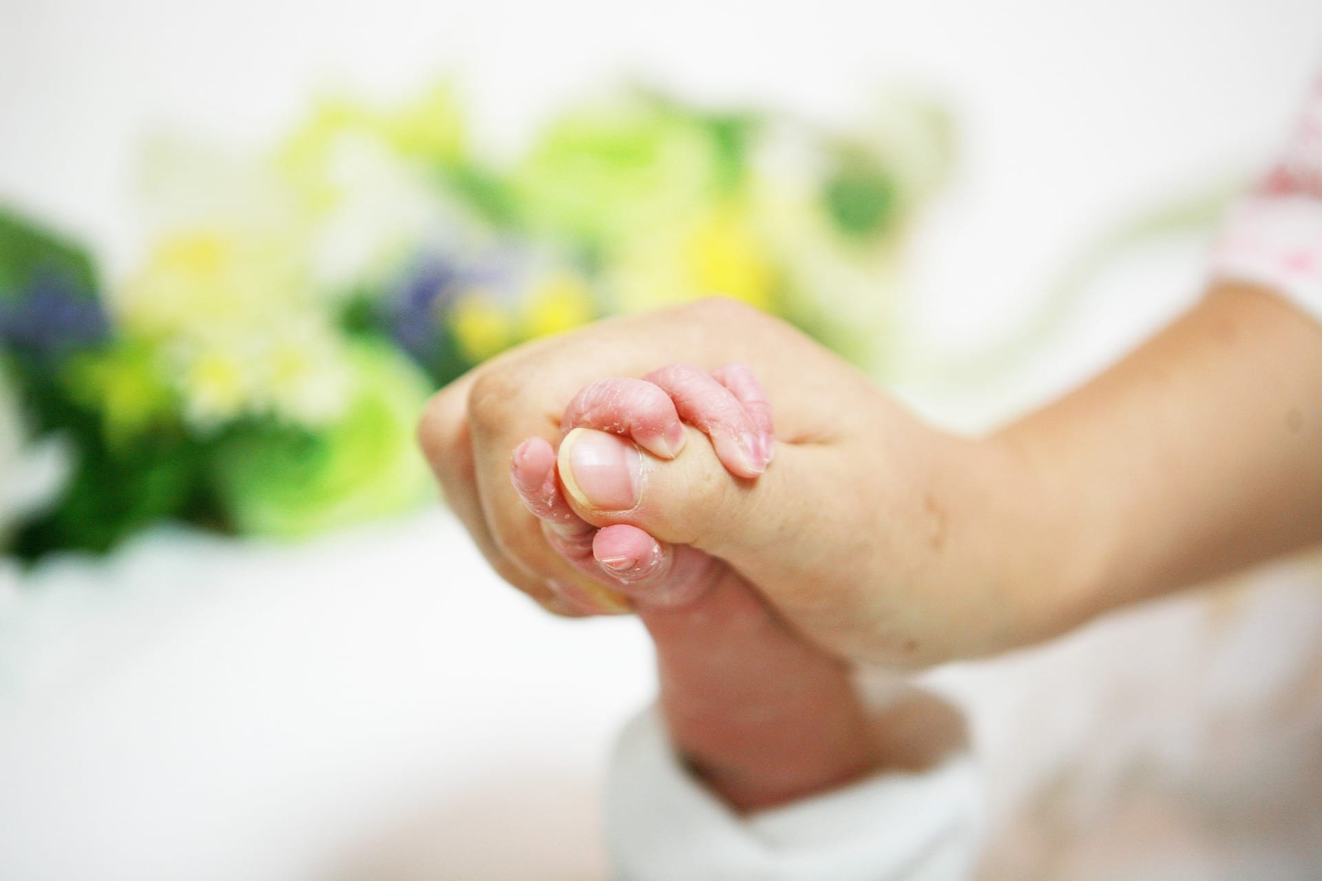 Mother and infant holding hands; image by hwanghyeongchae, via Pixabay, CC0.