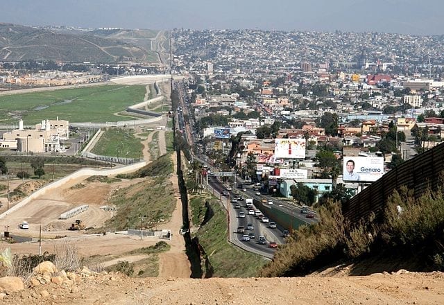 A view of the border between the U.S. and Mexico in southern California. On the Mexican side, Tijuana is full of buildings, cars, and life. On the right, San Diego seems empty in comparison.