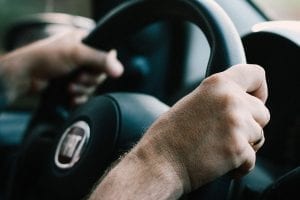 Image of a driver with their hands on the steering wheel