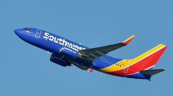 A blue, orange and red Southwest Airlines airplane takes off into a cloudless sky. Photo by Eric Salard, via Flickr. CC BY-SA 2.0, image cropped.