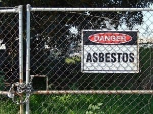 Chain-link gate with a “Danger – Asbestos” sign; image by Michael Coghlan, via Flickr, CC BY-SA 2.0, no changes.
