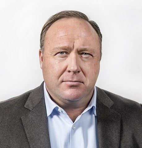 Radio personality Alex Jones, wearing a suit jacket and looking into the distance.