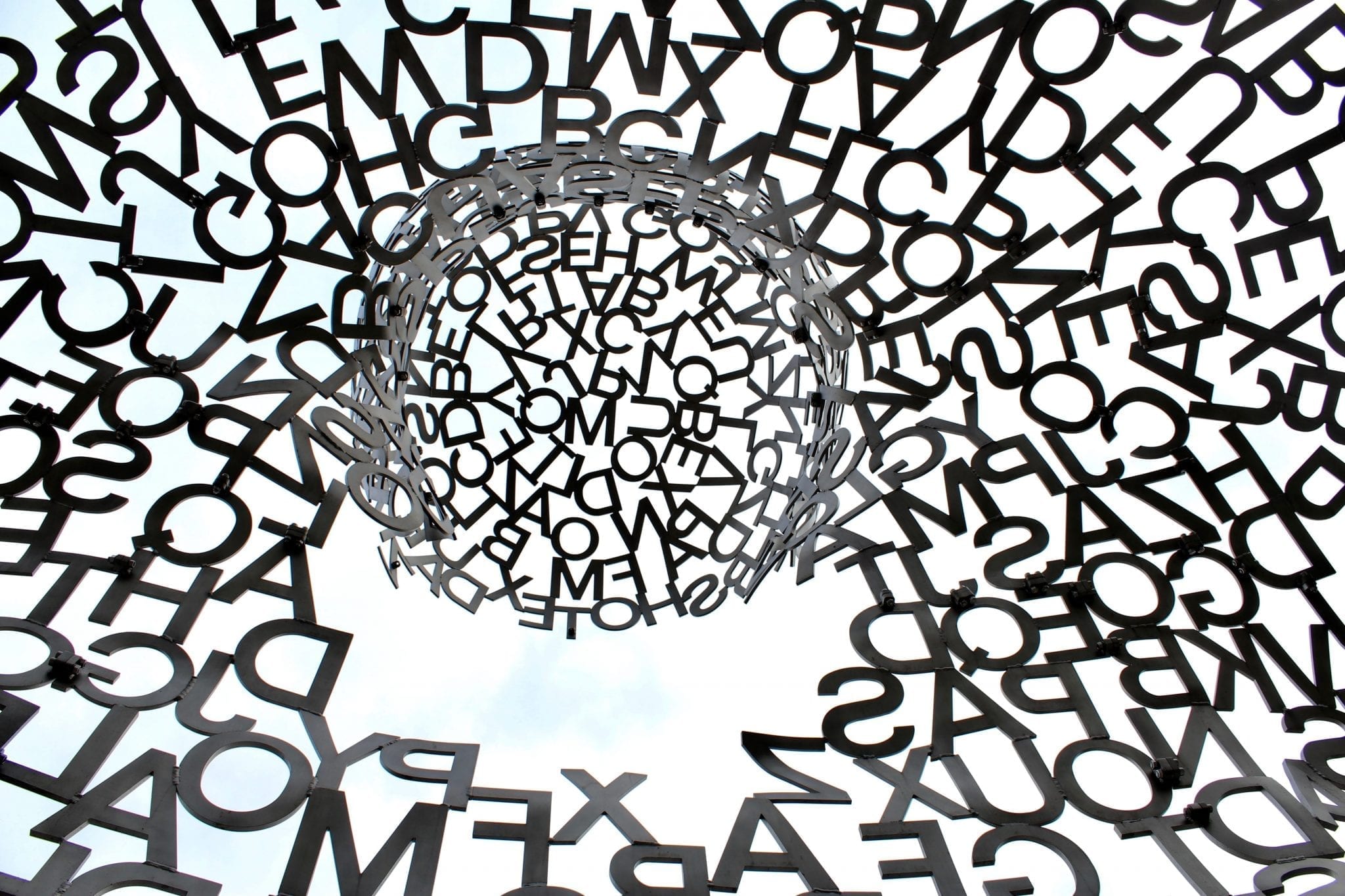 Black swirl of letters; image by Nathaniel Shuman, via Unsplash.com.