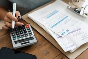 Woman working on financial documents; image by Rawpixel, via Unsplash.com.