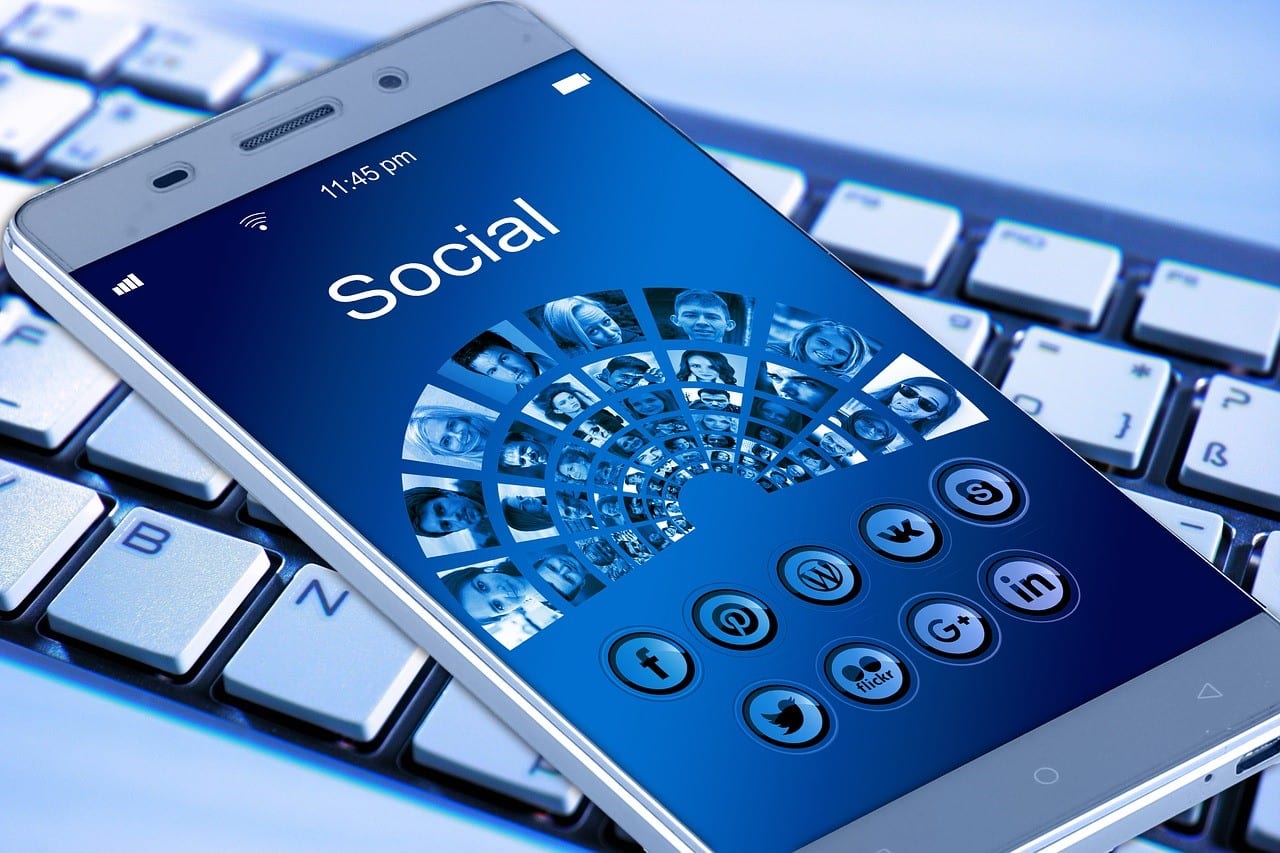 Smartphone displaying social media on top of a computer keyboard; image by geralt, via Pixabay.com, CC0.