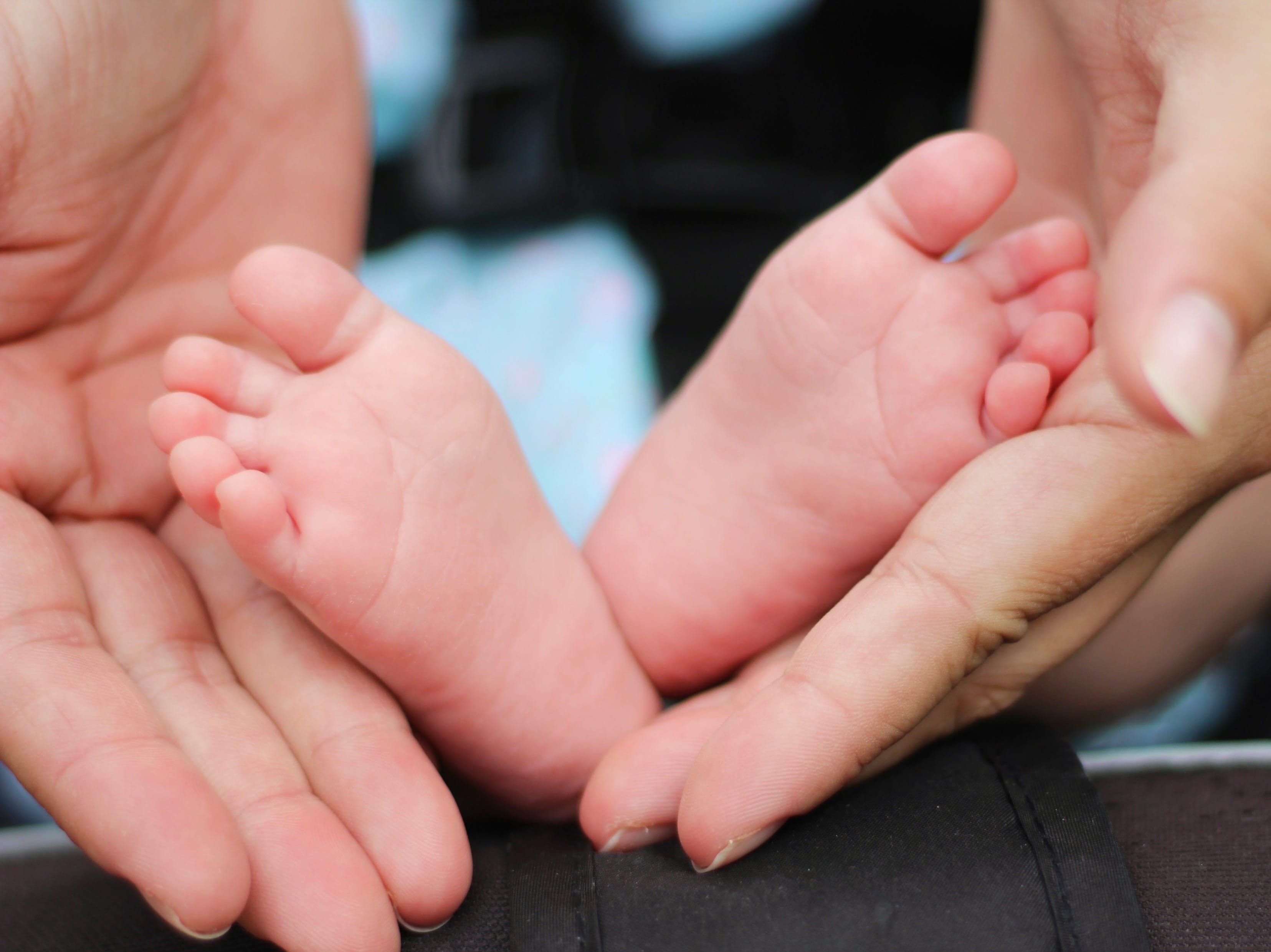 Woman holding a baby’s feet; image by Bonnie Kittle, via Unsplash.com.