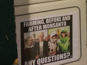 Flyer saying “Farming, before and after Monsanto. Any questions?” with Grant Wood’s American Gothic on the left and a modified version with the couple wearing hazmat suits on the right. Image by Kevin Krejci, via Flickr, CC BY 2.0, no changes.