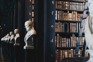 Library shelves with busts of famous people; image by Giammarco Boscaro, via Unsplash.com.