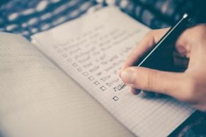 Man creating a list of tasks; image by Glenn Carstens-Peters, via Unsplash.com.