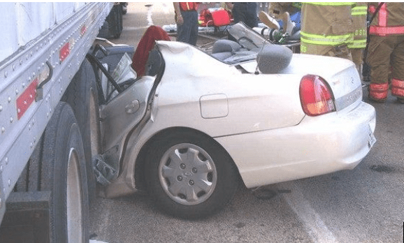 Car trapped under semi-trailer; image courtesy of author.