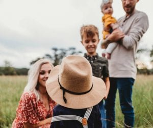 Man and woman with three children in a field; image by Jessica Rockowitz, via unsplash.com.