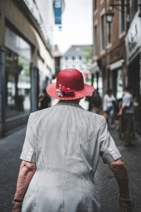 Woman in gray dress and red hat walking away; image by Fabio Neo Amato, via Unsplash.com.