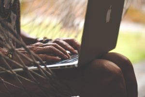 Woman with laptop on her lap; image by Trinity Treft, via Unsplash.com.