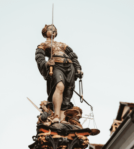 Statue of Lady Justice, blindfolded, holding sword and scale; image by Joel & Jasmin Førestbird, via unsplash.com.