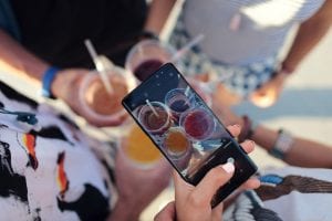 Person taking a picture of mixed drinks; image by David Calderón, via Unsplash.com.