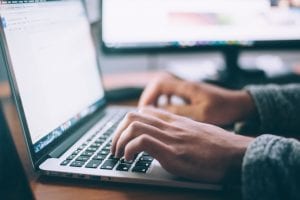 Man typing on laptop computer; image by Glenn Carstens-Peters, via unsplash.com.