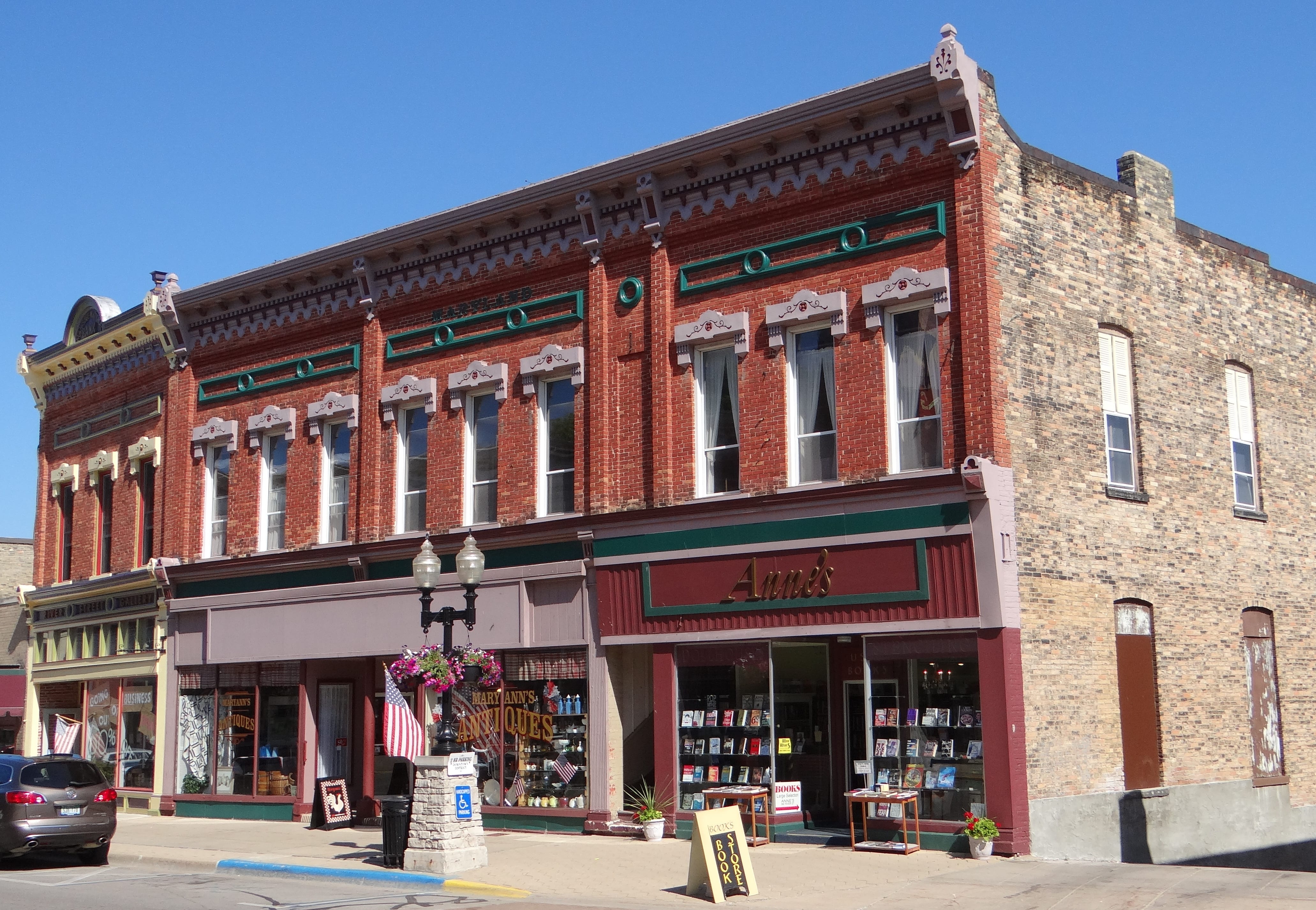 A row of two-story brick storefronts with a historic, small-town look.