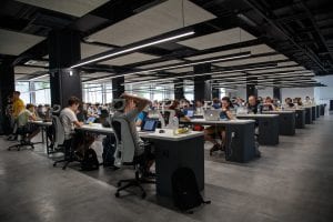 People working at various computer desks; image by Alex Kotliarskyi, via Unsplash.com.