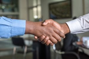 Two men shaking hands; image by Cytonn Photography, via Unsplash.com.