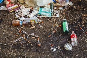 Used syringes, soda bottles, and assorted trash; image by Jonathan Gonzalez, via Unsplash.com.