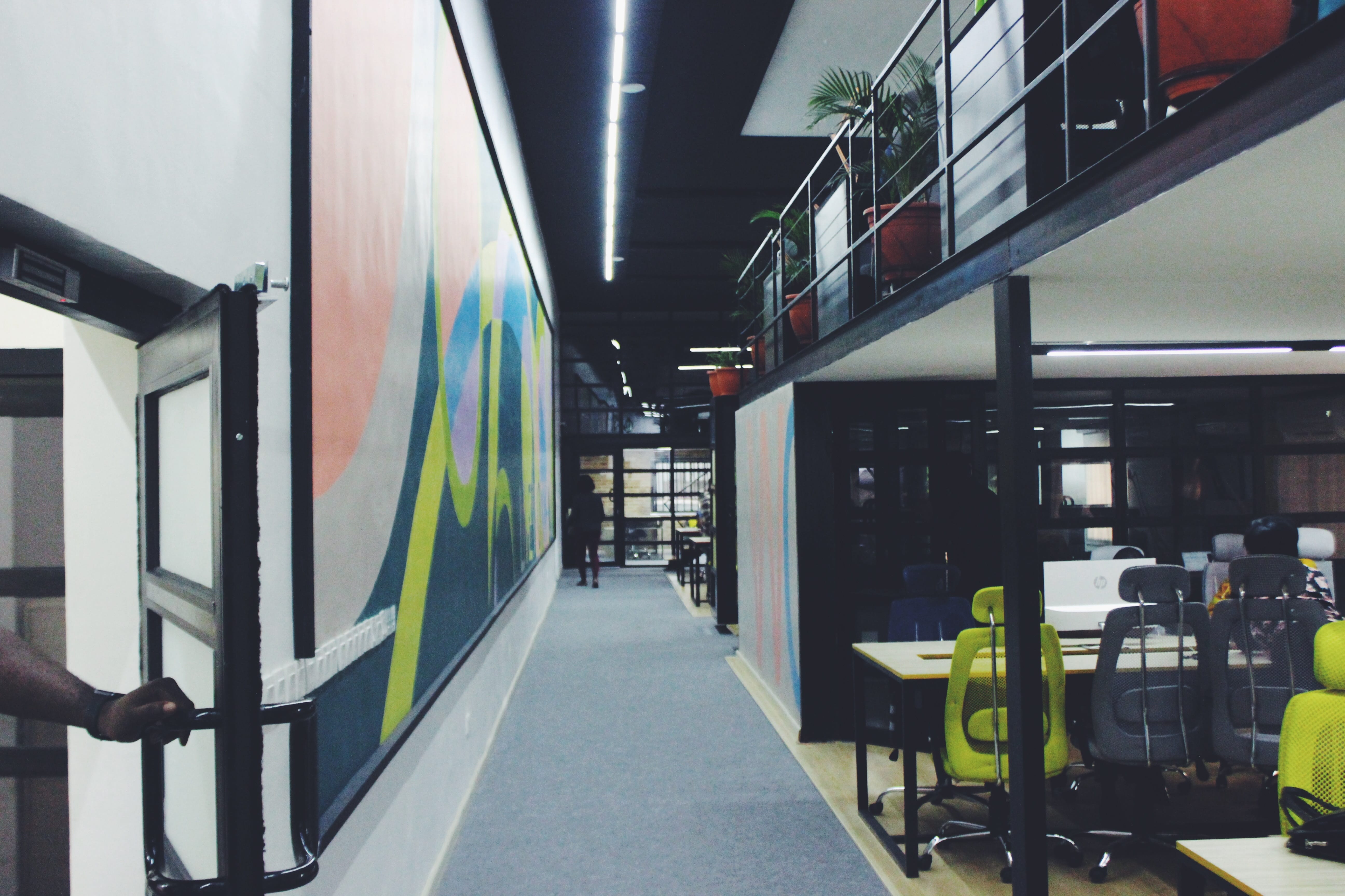 Long workplace hallway with grey carpet; image by Kolapo Oni, via Unsplash.com.