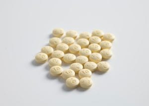 Round yellow pills; image by Thought Catalog, via Unsplash.com.
