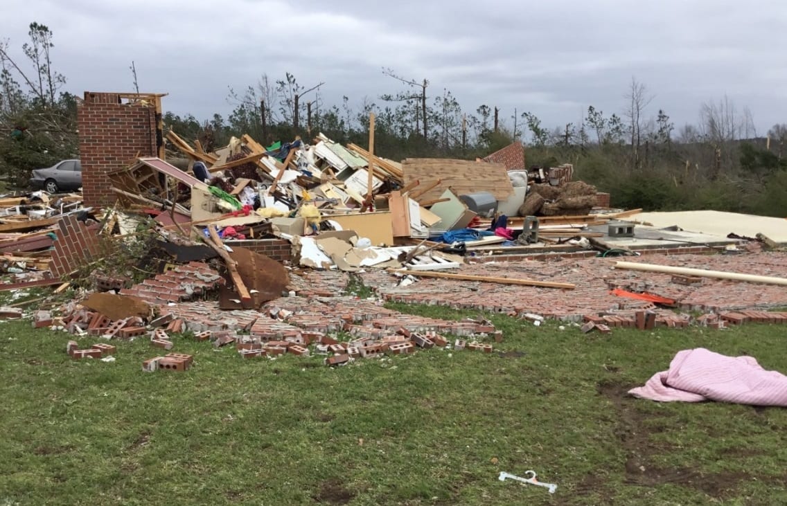 Image of a home leveled by a tornado, surrounded by debris.