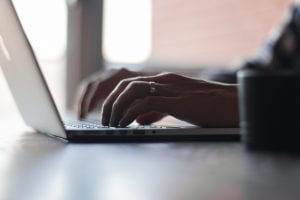 Man using laptop; photo by Thomas Lefebvre on Unsplash.