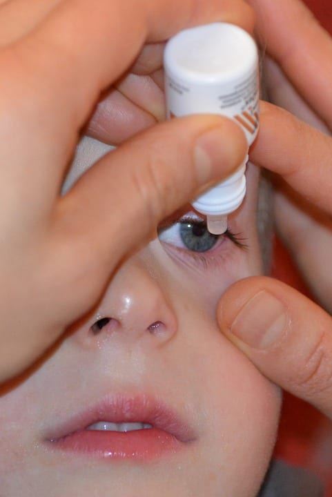 Applying eye drops to a child
