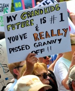 A protester carrying a sign that says, "My Grandkids Future is #1 & You've Really Pissed Granny Off!!"