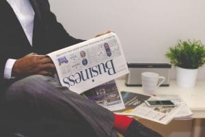 Man reading business newspaper; image via Adeolu Eletu, via Unsplash.com.