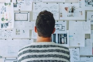 Man looking at project planning bulletin board; image by StartupStockPhotos, via Pixabay.com.