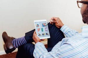 Man reviewing project status on a tablet; image by Adeolu Eletu, via Unsplash.com.