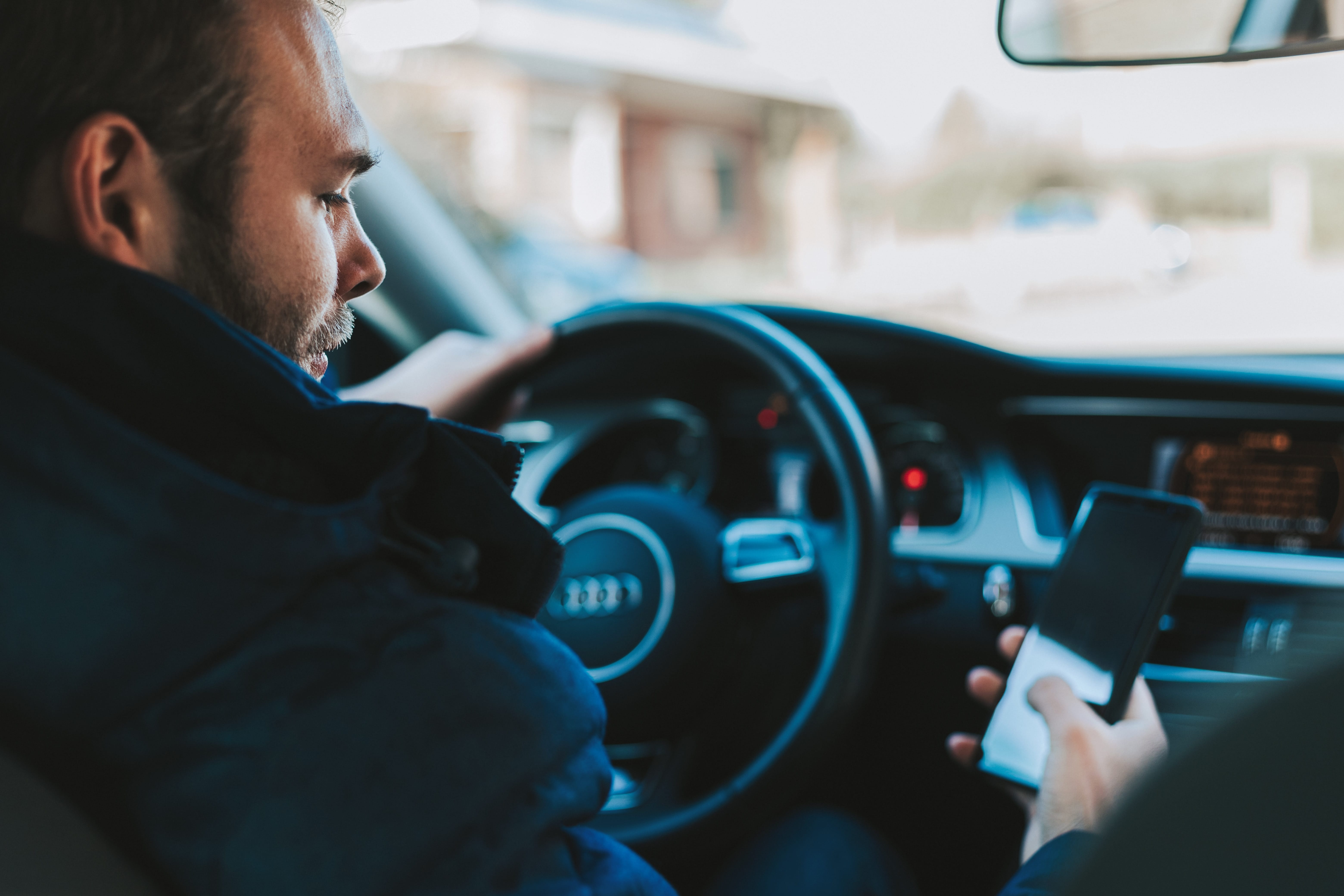 Man texting and driving; image by Alexandre Boucher, via Unsplash.com.