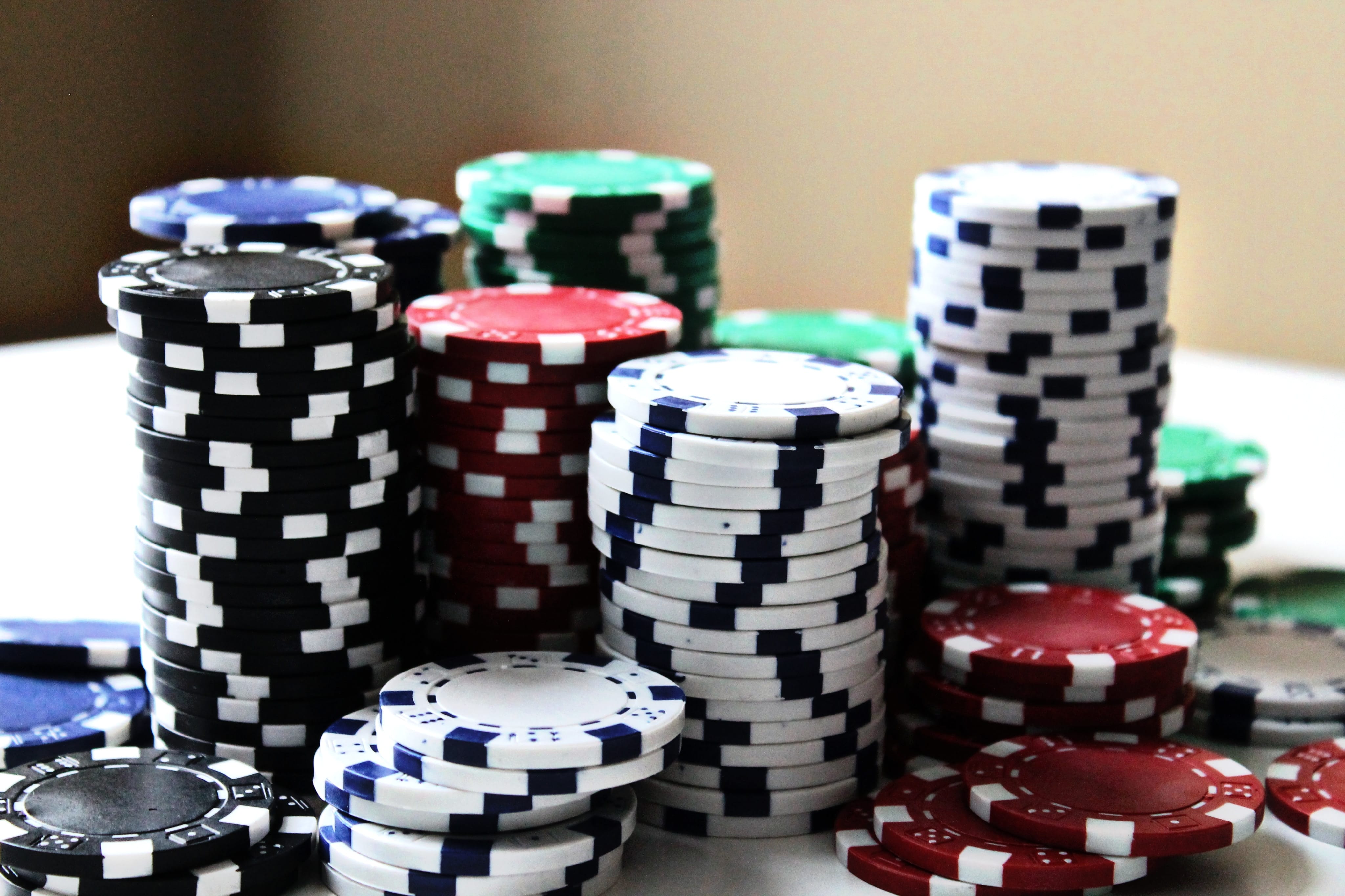 Stacked poker chips of various colors; image by Amanda Jones, via Unsplash.com.