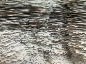 Pile of papers; image by Christa Dodoo, via Unsplash.com.