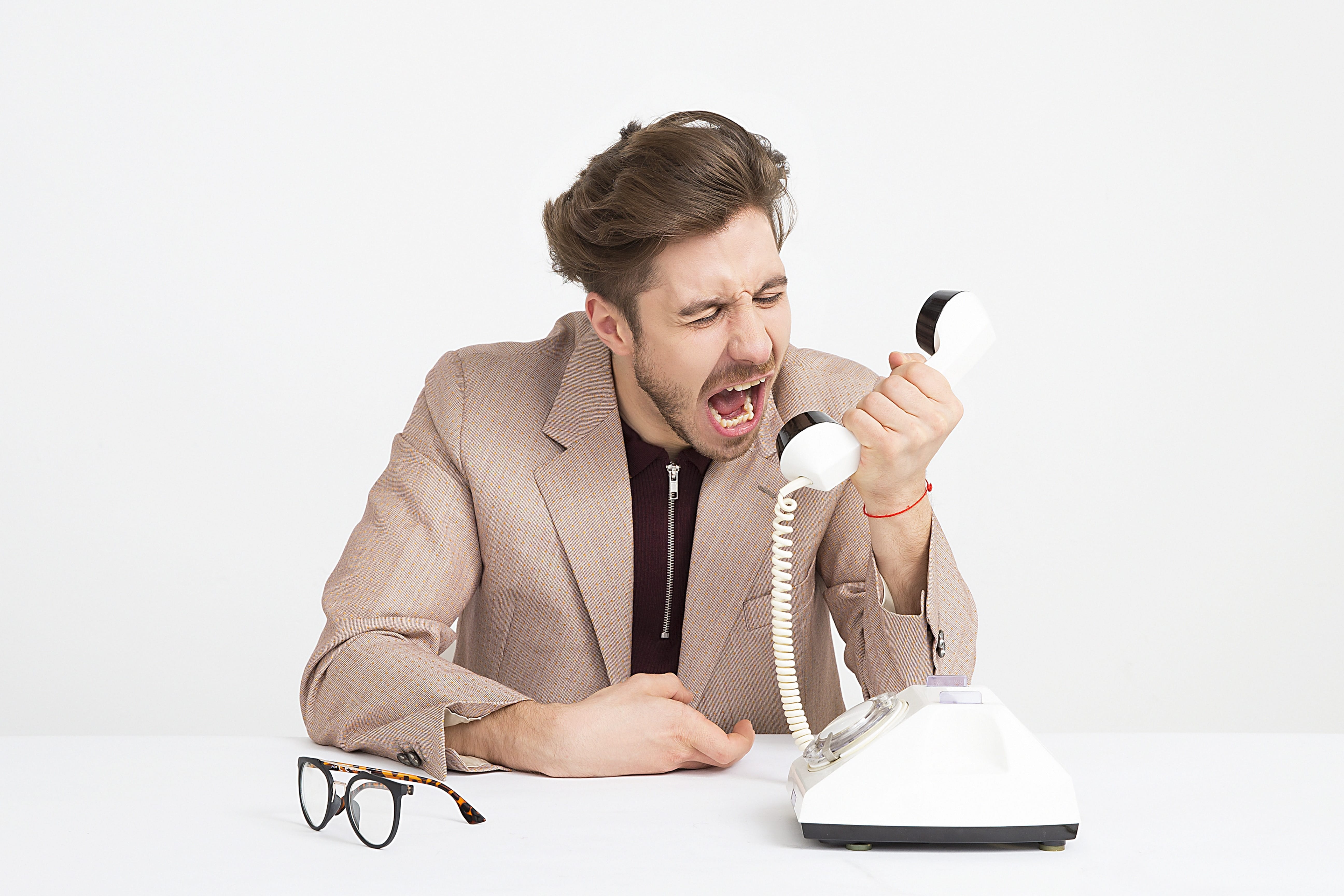 Man screaming into telephone; image by Icons8 Team, via Unsplash.com.