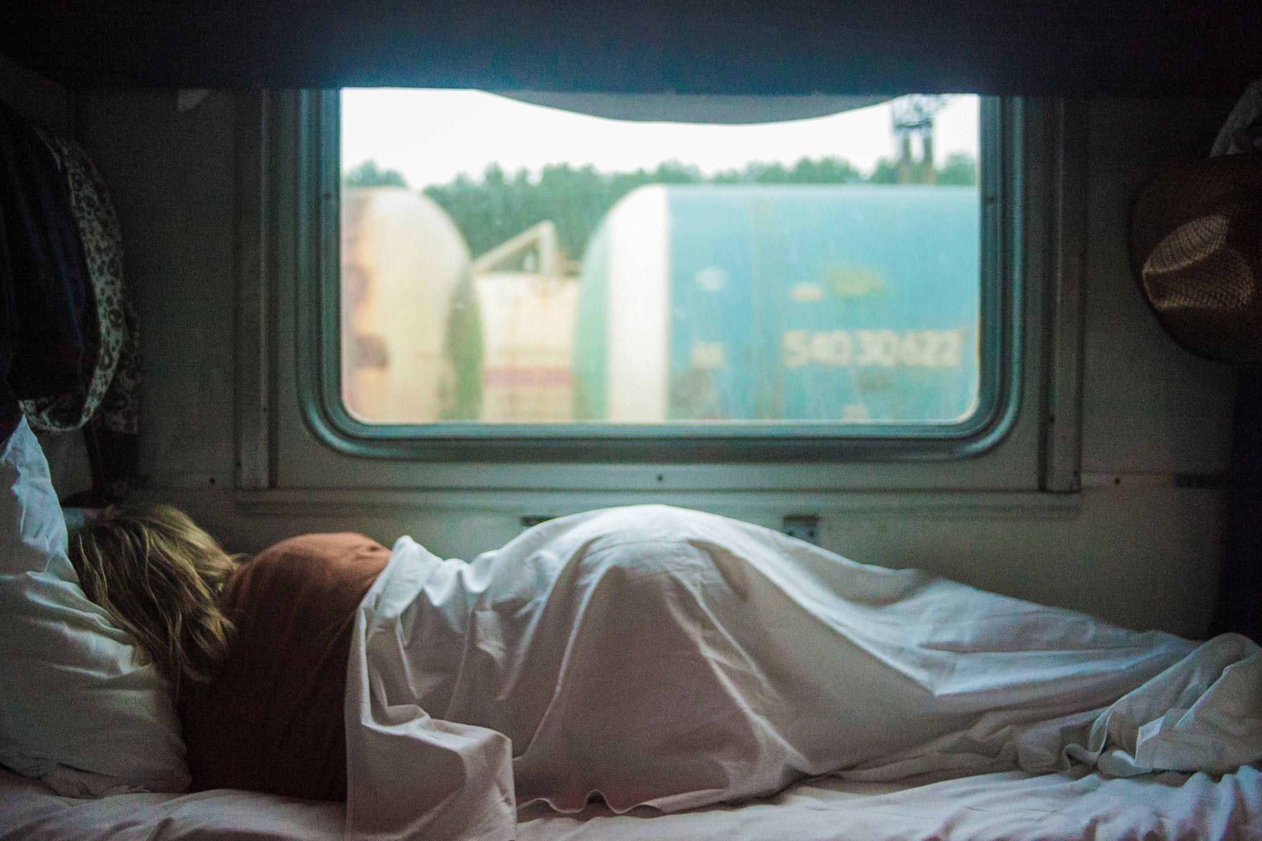 Woman sleeping in front of window in daylight; image by Kalegin Michail, via Unsplash.com.