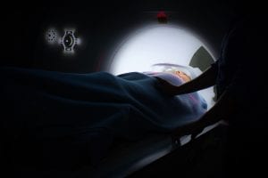 Person in CT scanner; image by Ken Treloar, via Unsplash.com.