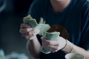 Woman counting cash; image by Sharon McCutcheon, via Unsplash.com.