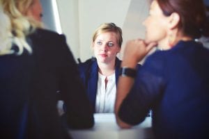 Three women at a table; image by Tim Gouw, via Unsplash.com.